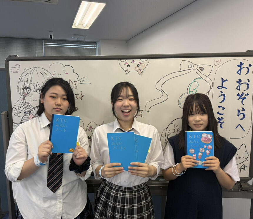 キャンパスの教室で生徒がみらいノートを手に写真撮影をしている様子