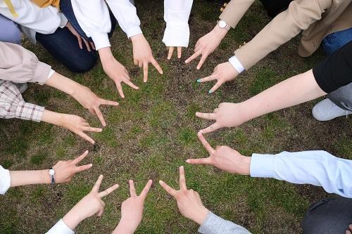 生徒たちが円になってピースしている様子を上から撮影した写真