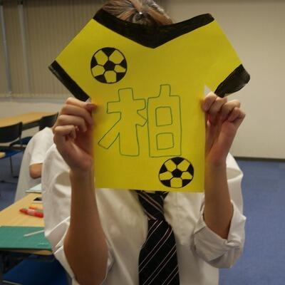 柏キャンパスの在校生が、キャンパスブースで使用する制作物と一緒に撮っている写真