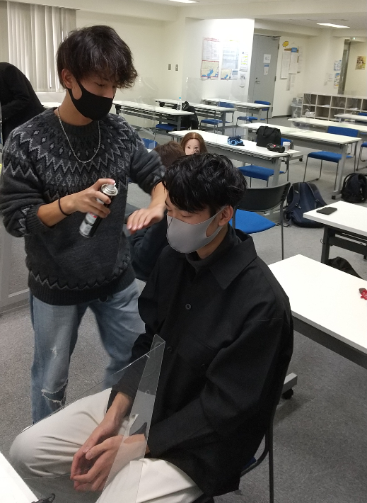 ヘアメイクを楽しんで学ぶ男子生徒