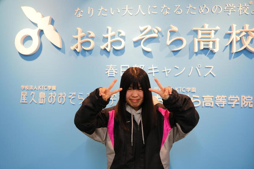 インタビュー生徒が笑顔でピースしている様子