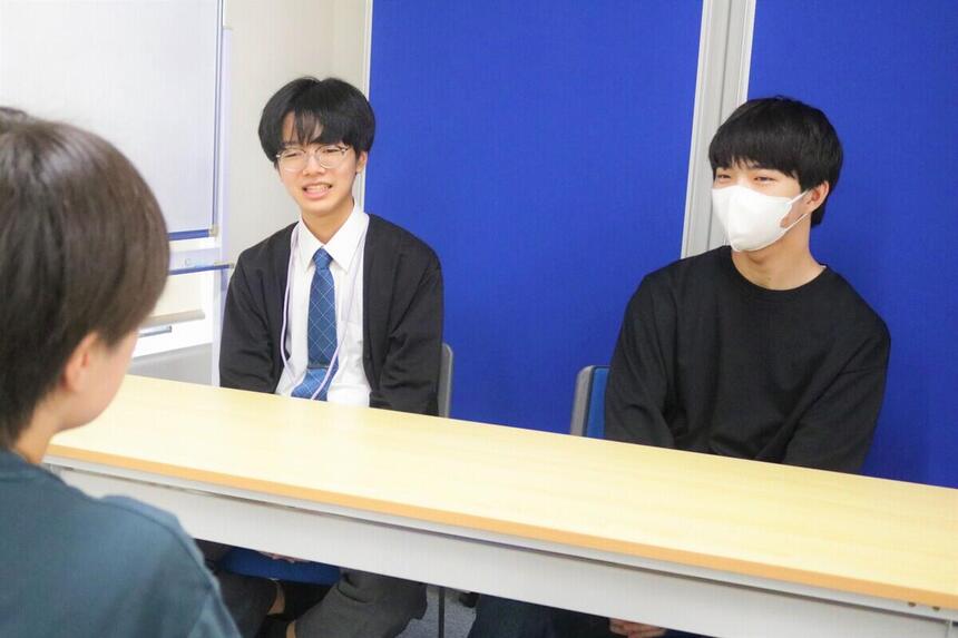 教室でコーチと談笑する生徒