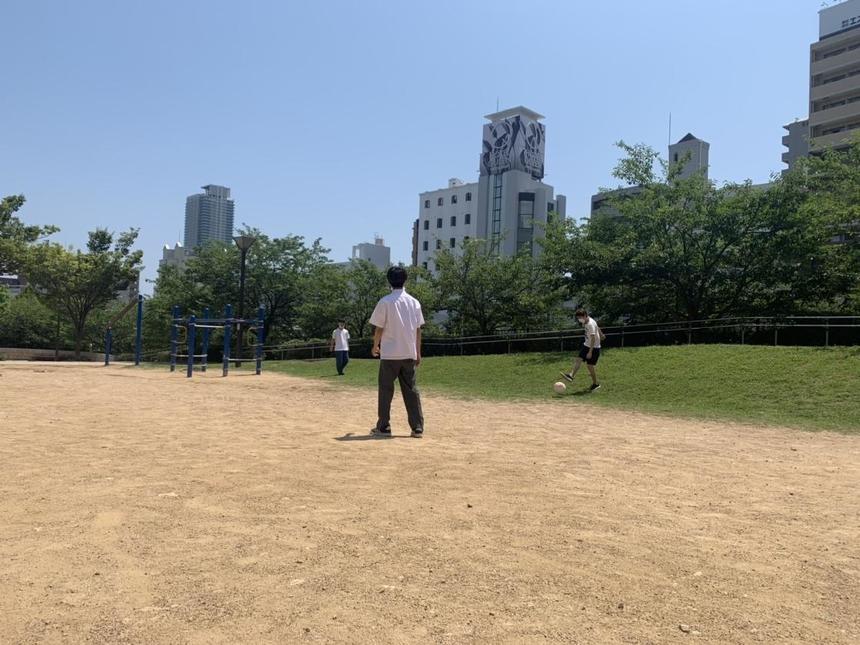 公園でサッカーをする生徒　