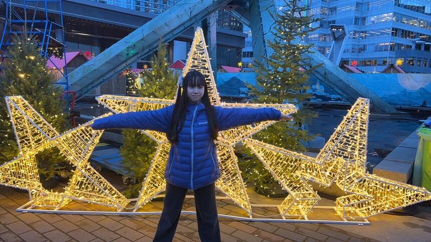 クリスマスマーケットのモニュメント前でポーズをとる神戸キャンパス在校生の図