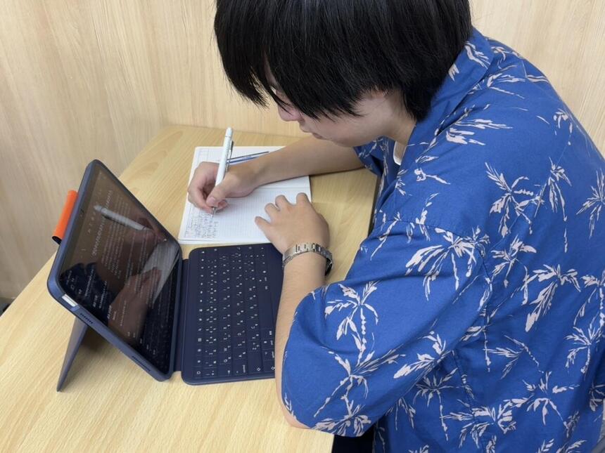 授業内容をタブレット端末で整理し、自分に合った方法でノートにまとめながら学習する生徒の様子