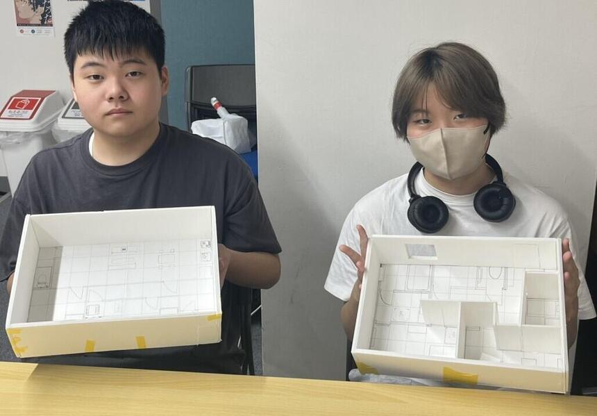 専門コース在籍の生徒が、授業終了後に自分たちが作った家の模型を見せてくれている写真
