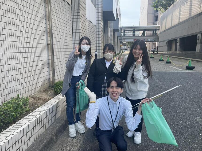 清掃活動中のコーチと生徒の写真