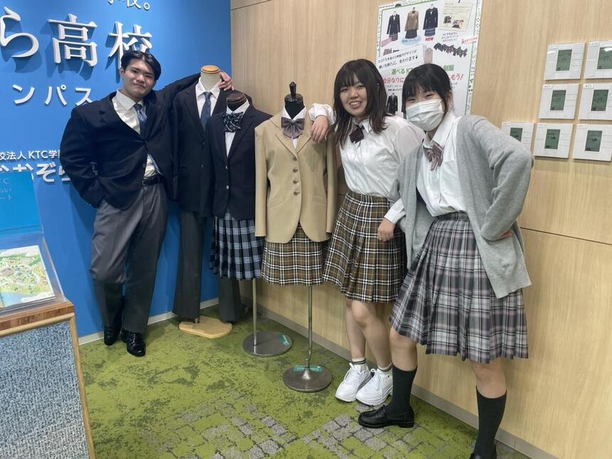 制服を着たマネキンと一緒に制服姿の男子生徒と女子生徒