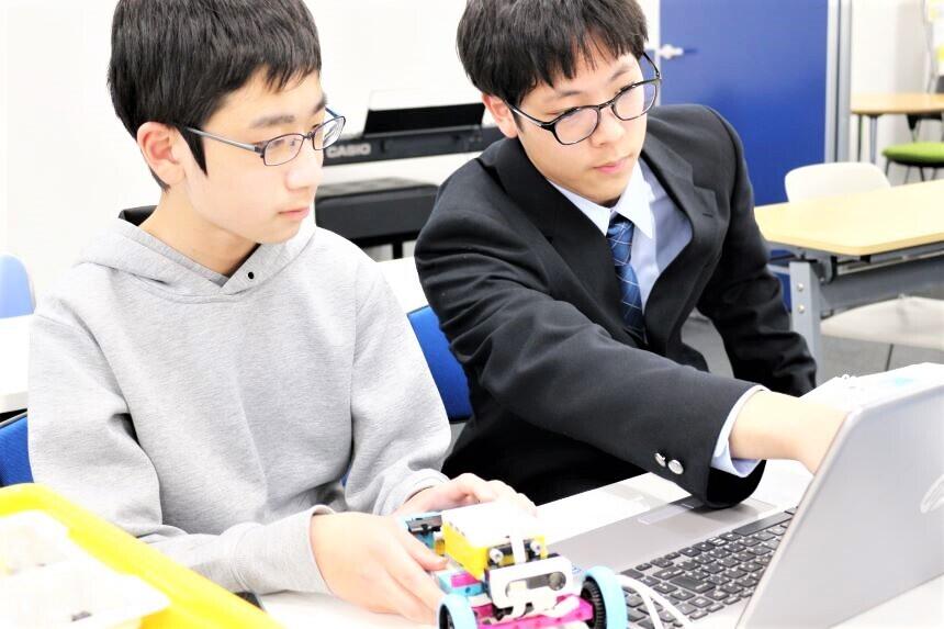 生徒が相談しながら一緒にプログラミングを考えている様子です。