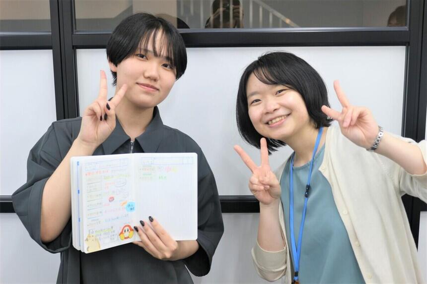 生徒が、KTCみらいノート®を手にマイコーチと一緒に撮った写真