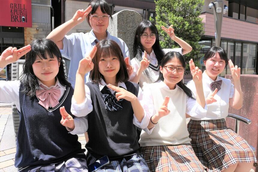 生徒が外でポーズを決めている集合写真