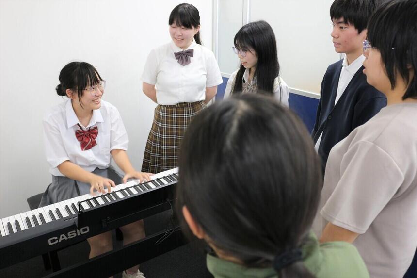 おおぞら杯の練習に向けてピアノを弾いている生徒の近くで歌をうたう生徒たち