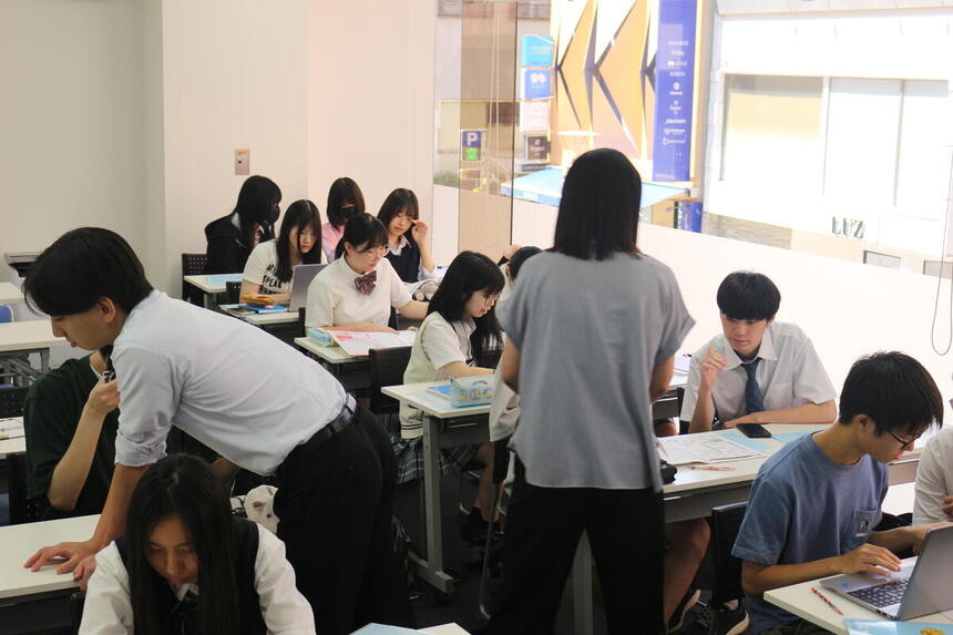 教室で生徒が、コーチと一緒に夏休みの振り返りを行い、進路について考えている様子
