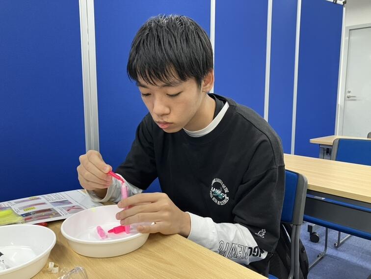 蛍光ペンの芯にインクを注ぐ生徒