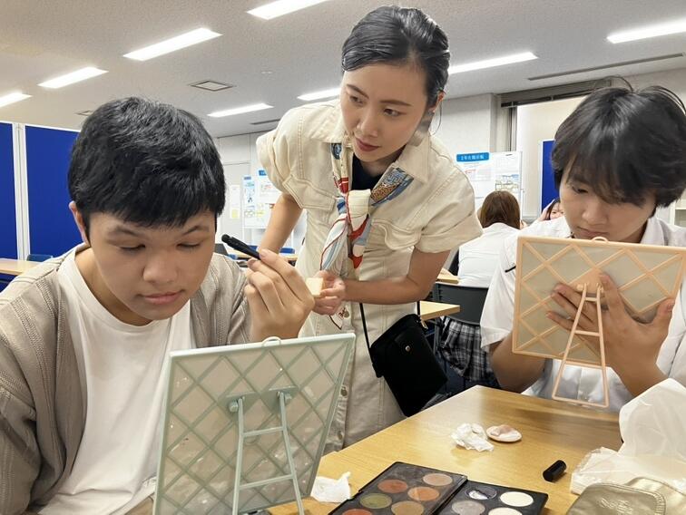 トータルビューティの授業で講師にメイク指導を受ける男子高校生