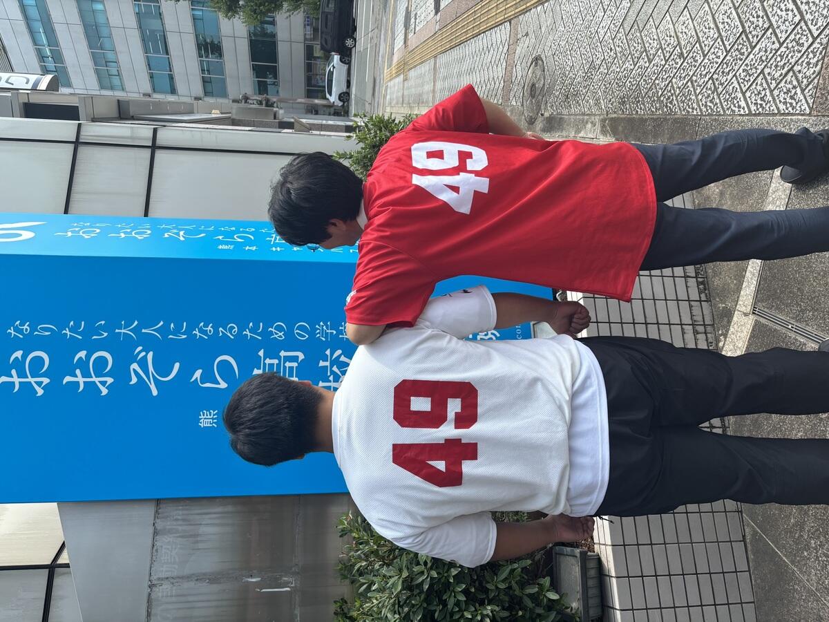 合宿で着用していたユニフォームを着てキャンパス前で写真を撮りました