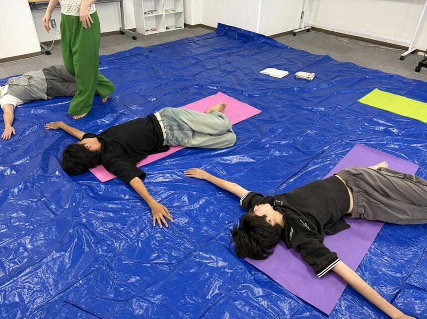 倉敷キャンパスにてみらいの架け橋レッスンのヨガをしてリラックスしている生徒の様子