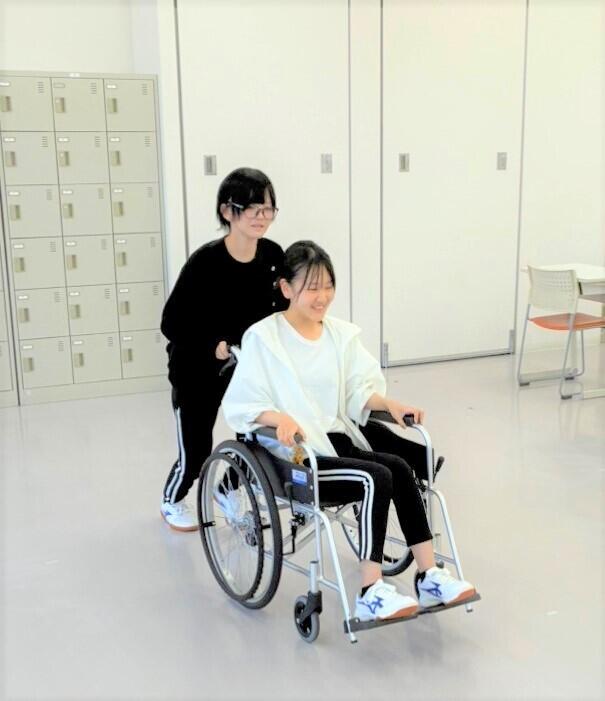 子ども・福祉コースの生徒が介護福祉実習で車いす体験をしている様子