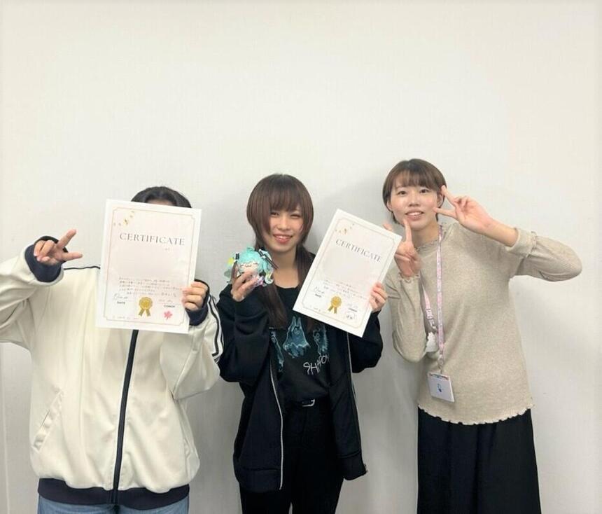 3人で一緒に楽し気に写真を撮りあうおおぞら杯に参加した生徒とコーチ