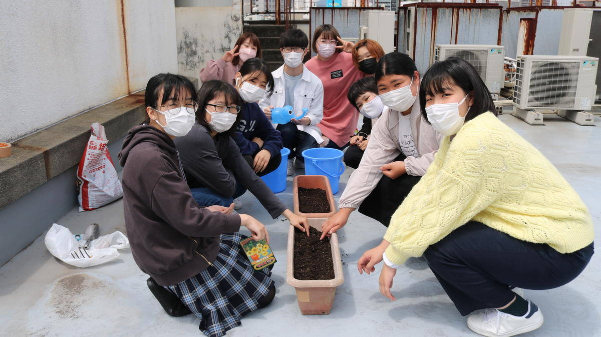 プランターに種をまく生徒