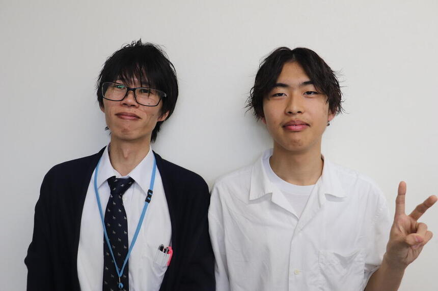 お昼休みに教室で写真を撮る男性コーチと男子生徒