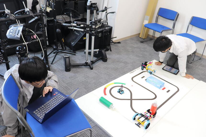 授業時間に教室でプログラミングの課題に挑戦をしている男子生徒2名