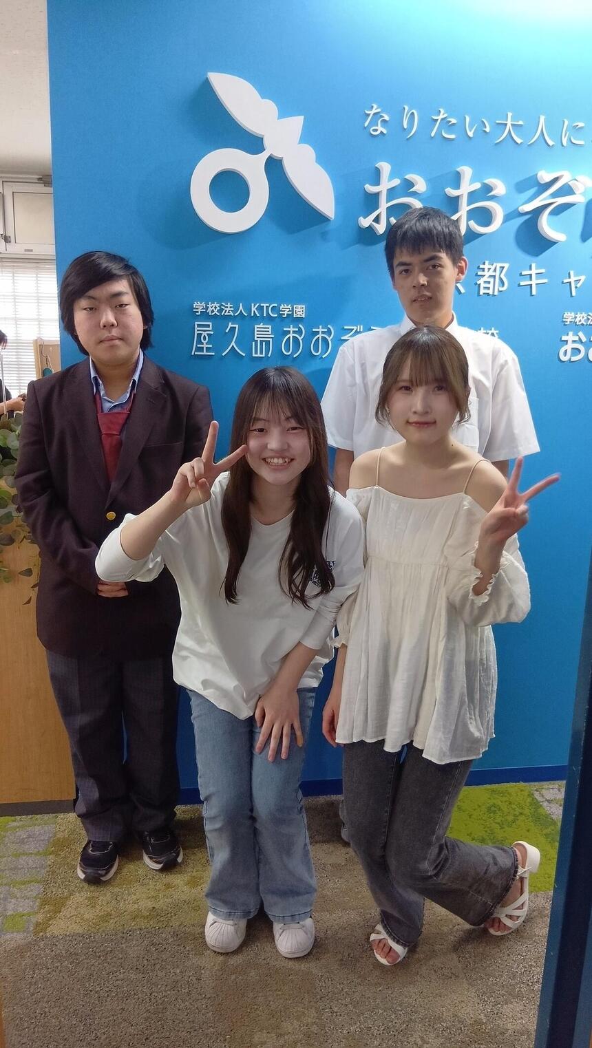 おおぞら高校京都キャンパスの生徒4名が制服や私服を着て笑顔で立っている画像。
