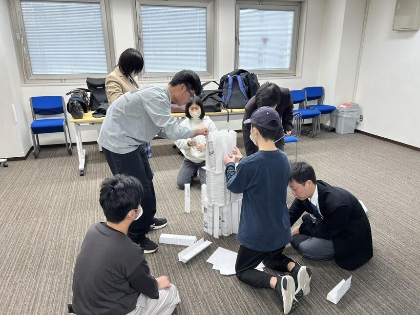 おおぞら高校 京都キャンパスの新入生レクリエーションにて、ペーパータワーに夢中な生徒