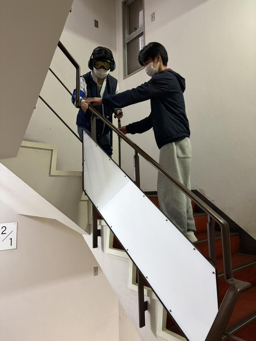 子ども・福祉コースの生徒が高齢者体験用具を付けて階段を上り下りしている様子