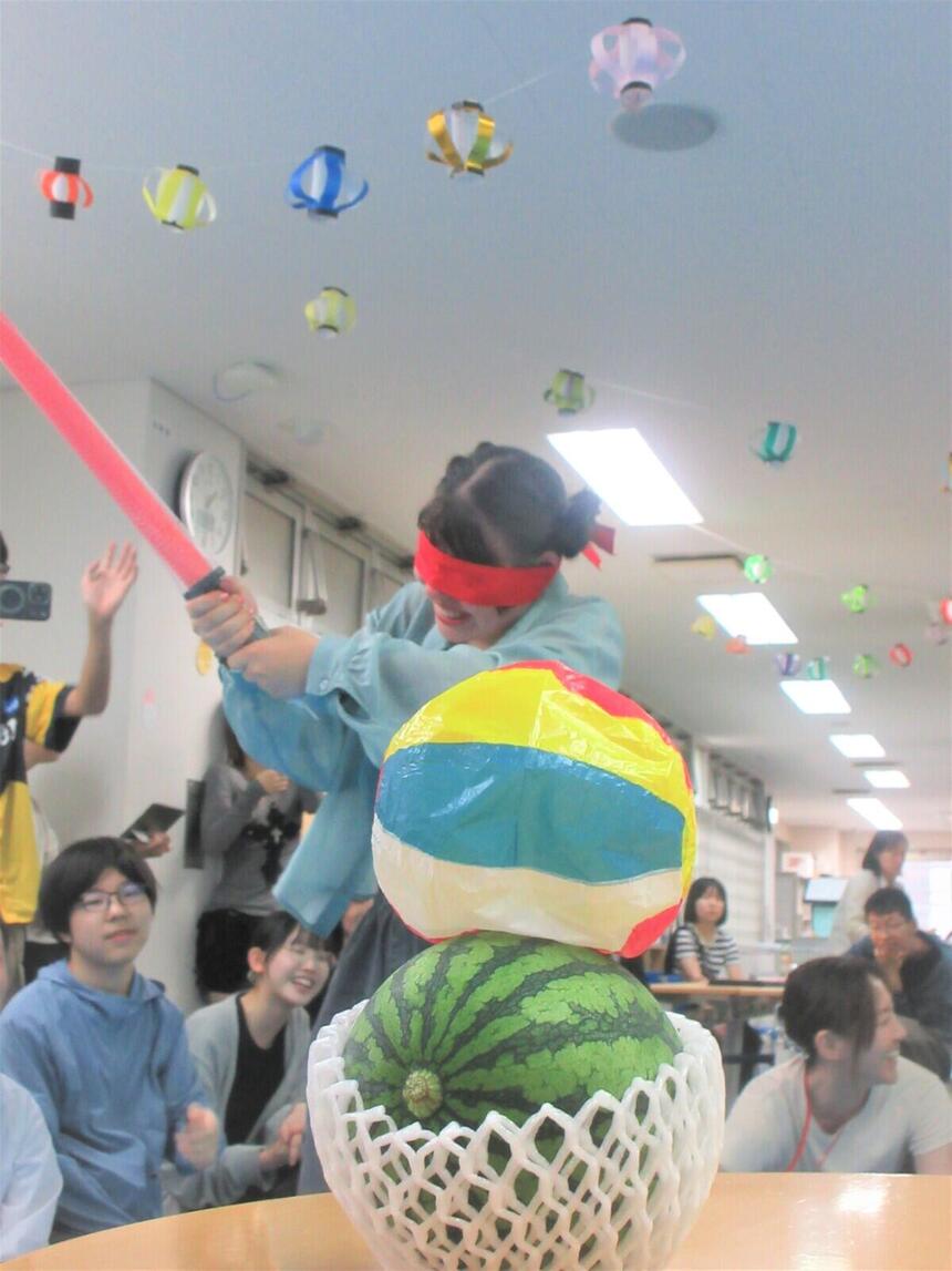夏休み前の夏祭りで生徒たちがスイカ割りをする様子
