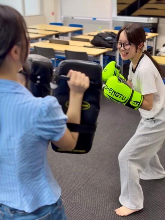 みらいの架け橋レッスンで、生徒がマイコーチや友だちと笑顔でミット打ちに挑戦している写真