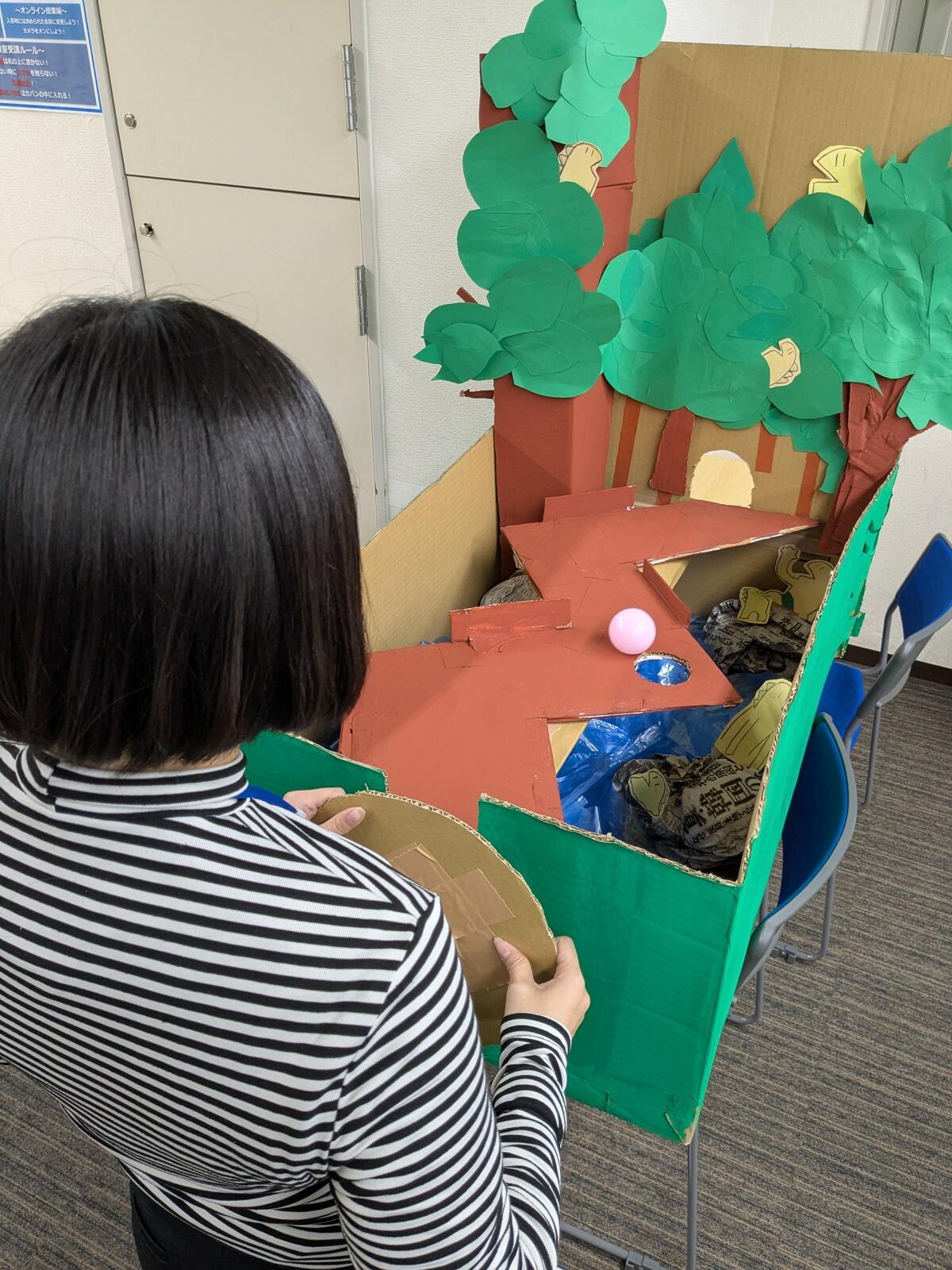 ジグザグのコースの上をバランスを取りながらボールを転がして、向こう岸まで運びます