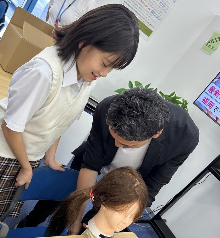 ヘアメイクの仕方を講師の先生に教えてもらっている