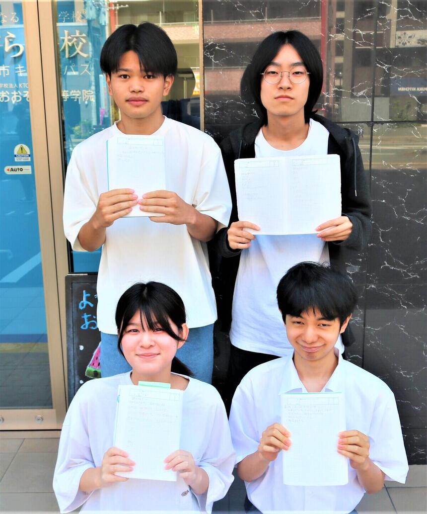 始業式にみらいノート®に書いたことを手に持って、玄関で生徒たちが映っている写真