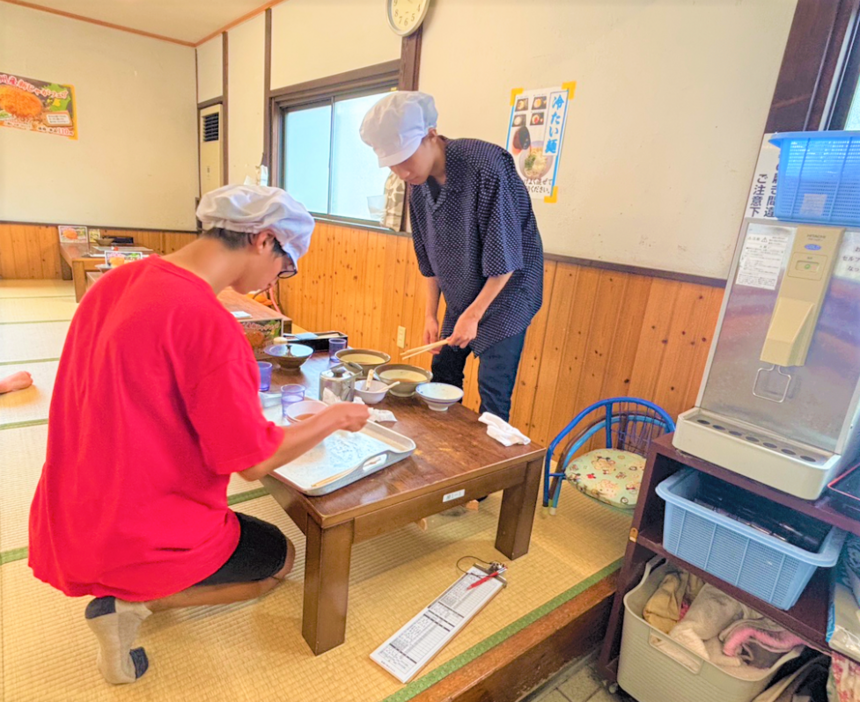 夏休みにキャンパス付近のうどん屋さんにて、一生懸命に職場体験をする高校生