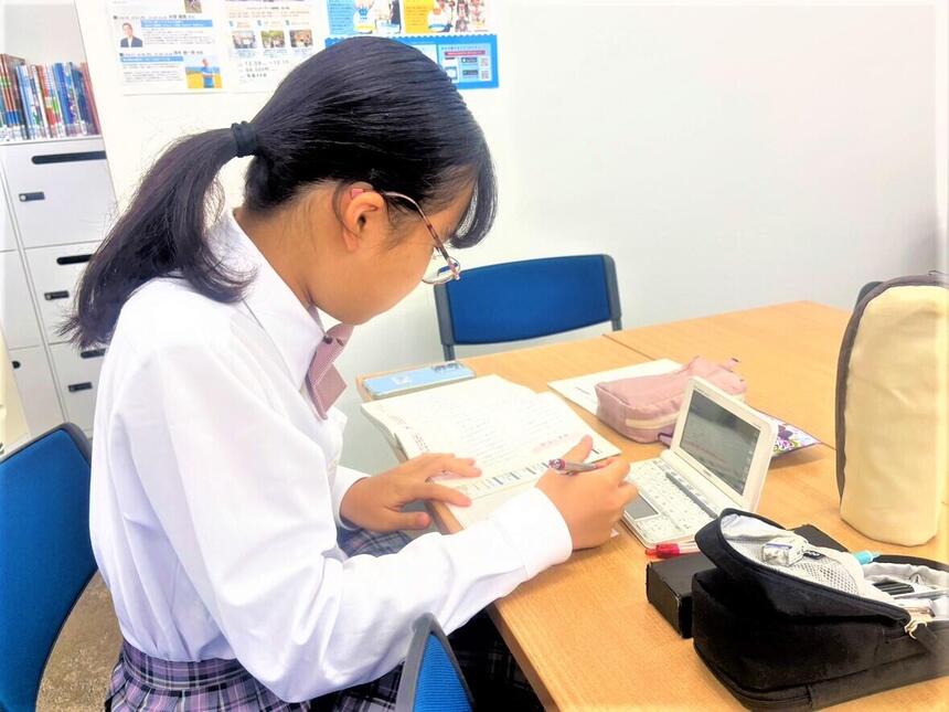 キャンパス内で進学コースの時間帯に、目標に向かって一生懸命学習に取り組む女子生徒