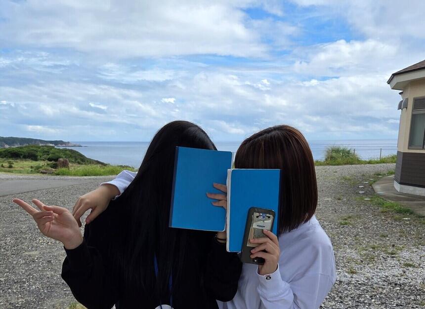 屋久島スクーリングで生徒たちが海と空を背景に撮った写真