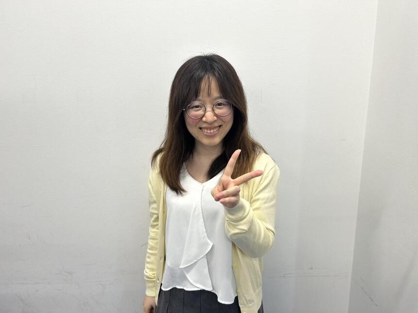 小林コーチが笑顔でピースをしている写真