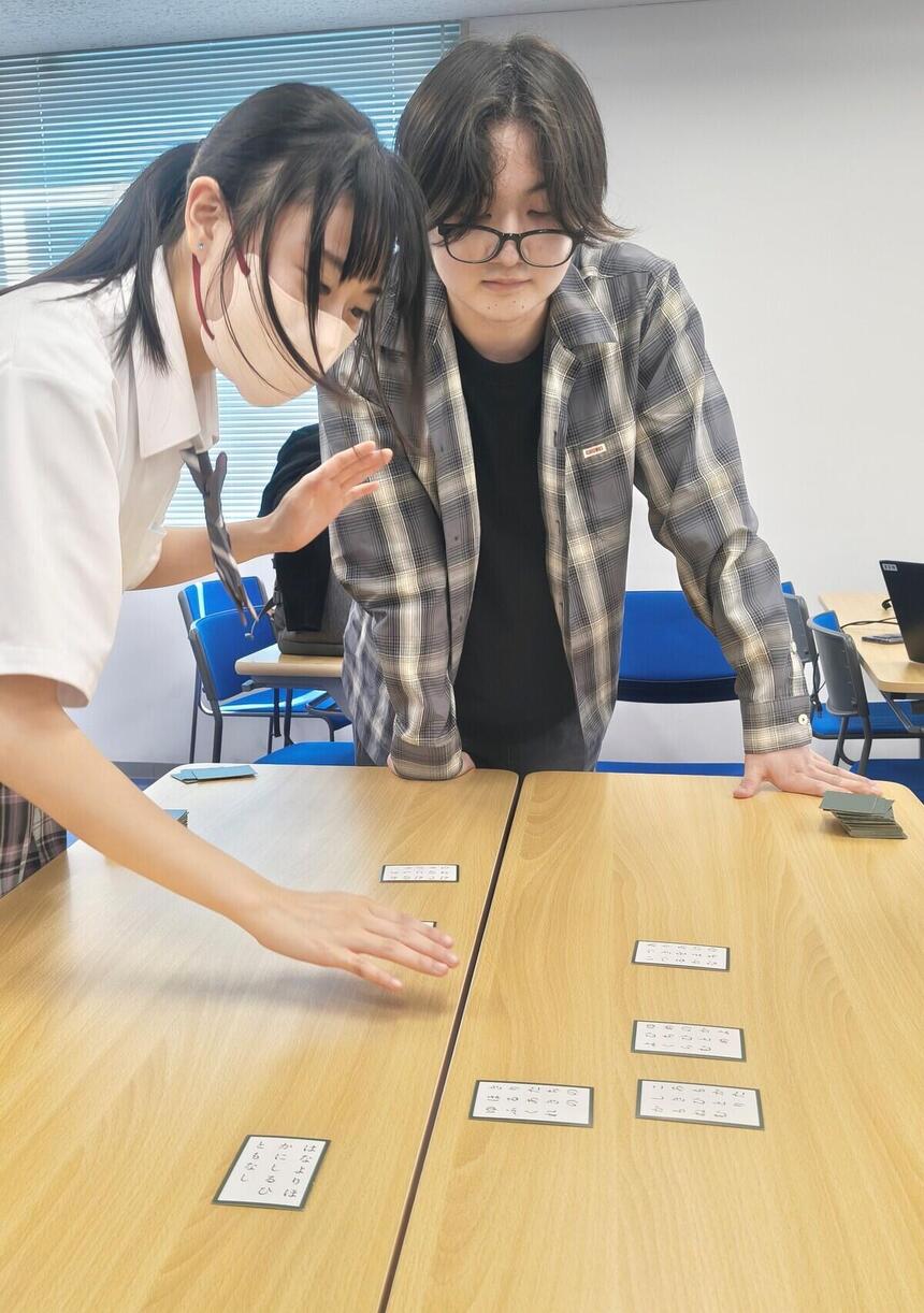 生徒が札を取ろうと構える姿の写真