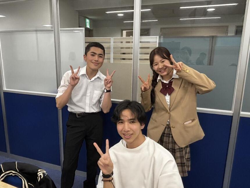 男子生徒2人と女子生徒1人がインタビュー後に笑顔を向けている写真