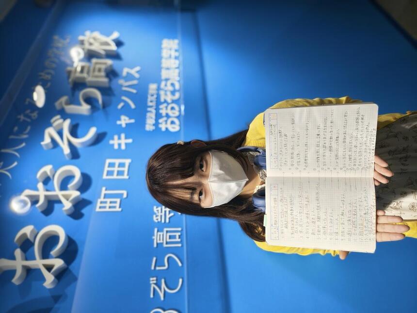 生徒がみらいノート®を手にキャンパスの入口に立つ写真