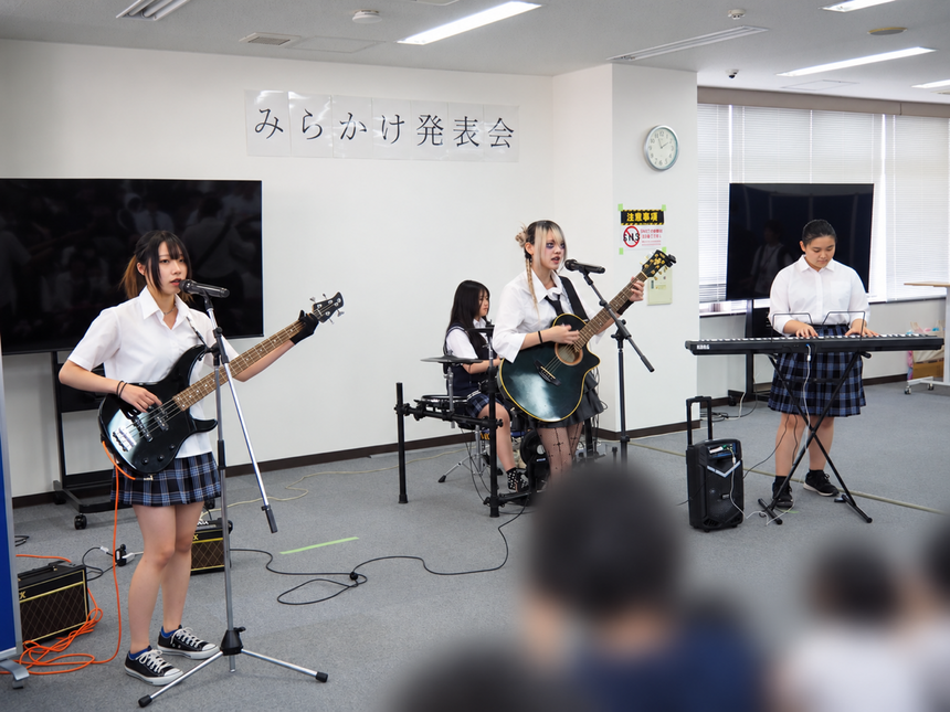 バンドで曲を演奏する生徒4人