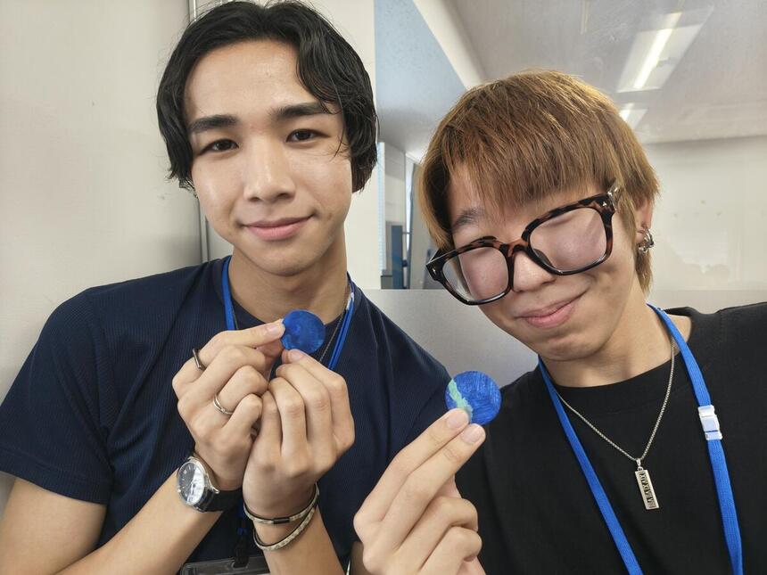 生徒2人が自分が作った作品と一緒に笑顔で立っている姿の写真　