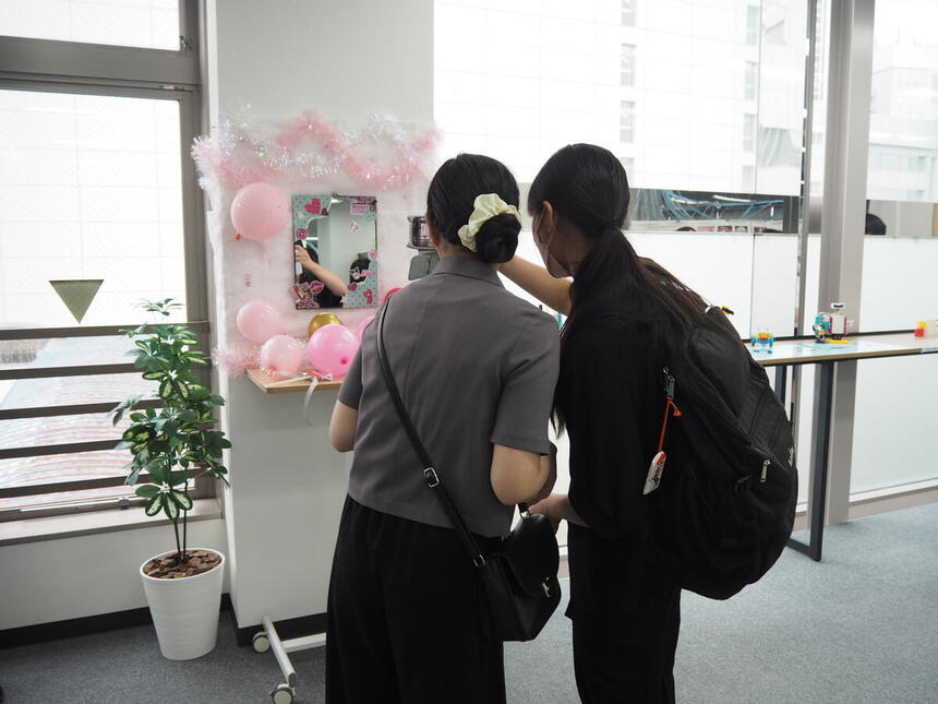 Machida Beauty Salonで制作したフォトスポットの前で、生徒が写真を撮る様子