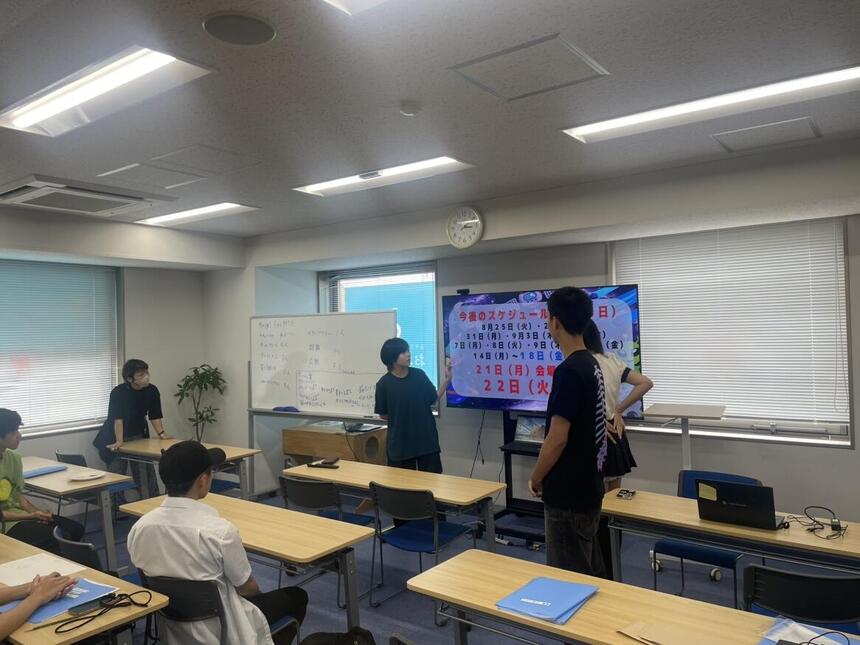 生徒3人がテレビの前で話をしている写真です。