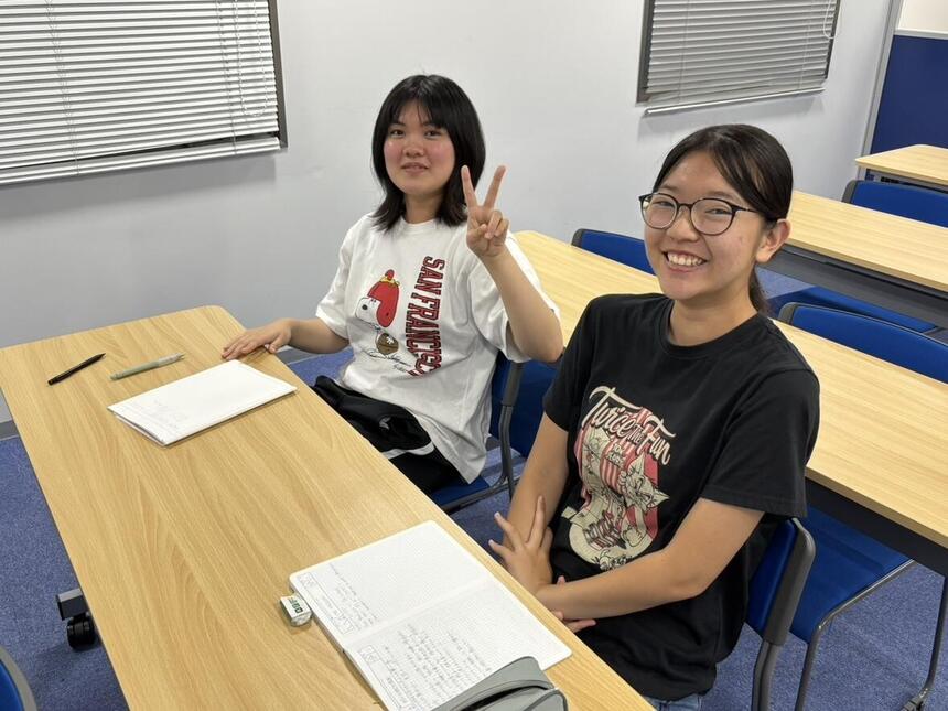 留学を前に事前学習を笑顔で受けている二人の生徒の様子　