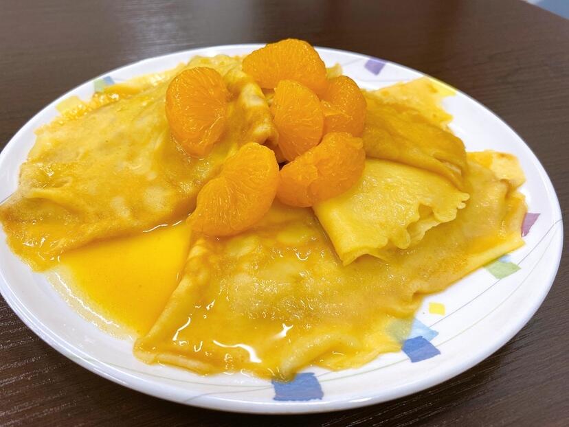 4つ折りにしたクレープ生地をオレンジソースで煮詰めたクレープシュゼット