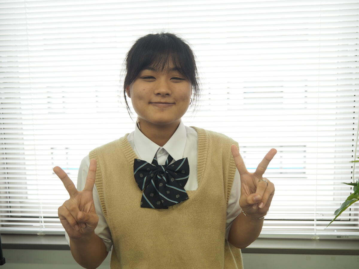 笑顔でダブルピースをする生徒