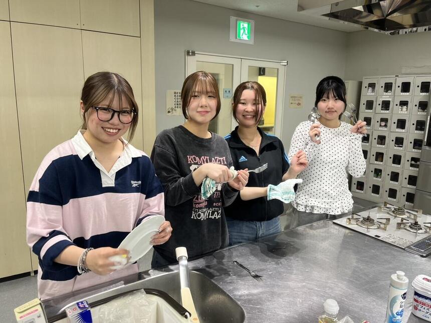 クッキングのレッスンに参加し協力して片づけをする1年生と3年生の様子