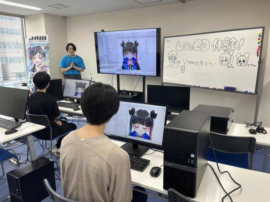LIVE2D体験前に講師の方の説明を真剣に聞く生徒とわかりやすく説明をしてくださっている講師の方の様子